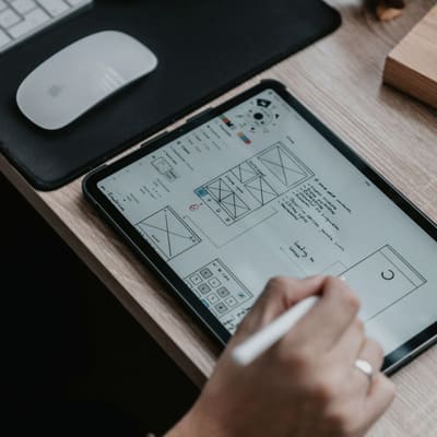 Tablet z rysowanym układem strony — wireframe w trakcie pracy.