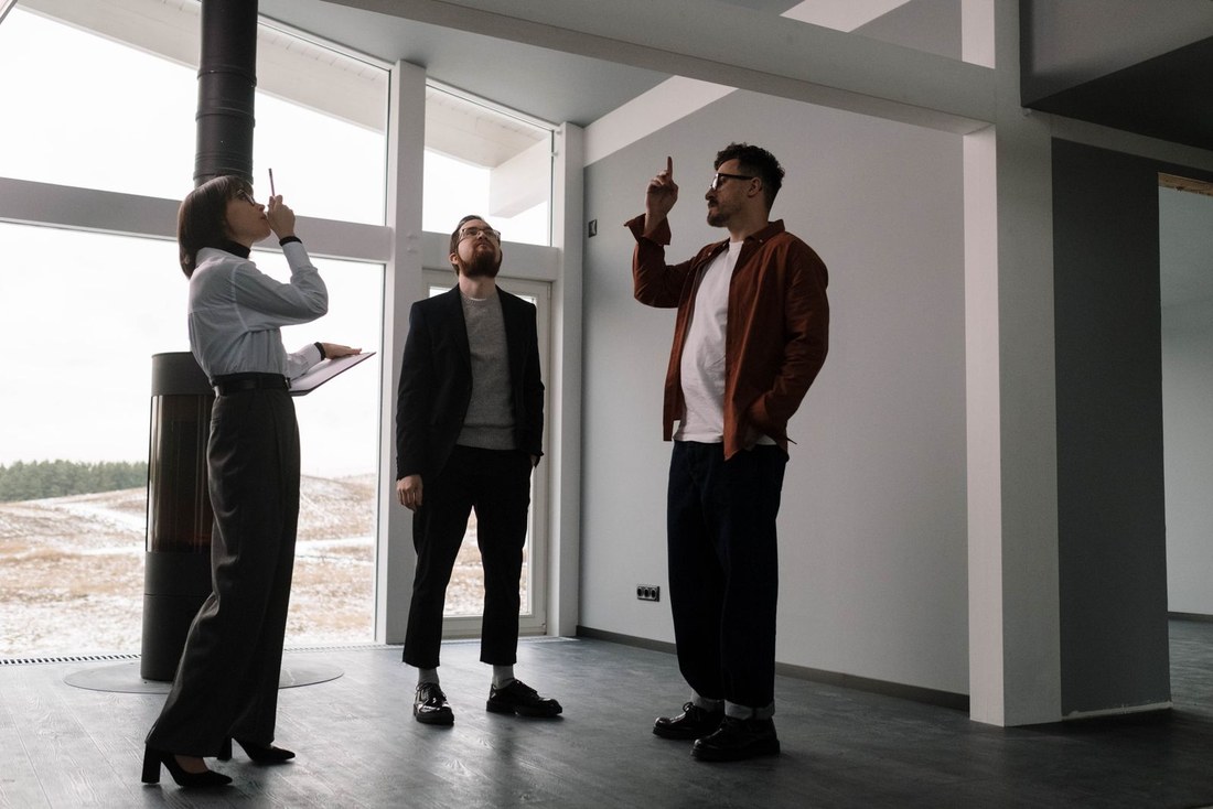 Architektka prowadzi rozmowę z klientami we wnętrzu przed rozpoczęciem projektu