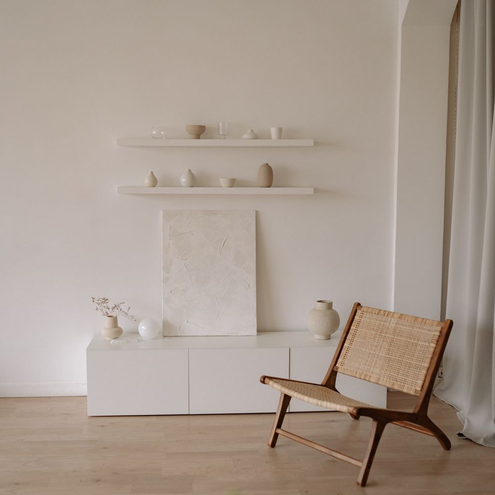 Jasna nisza z ceramiką i rattanowym fotelem