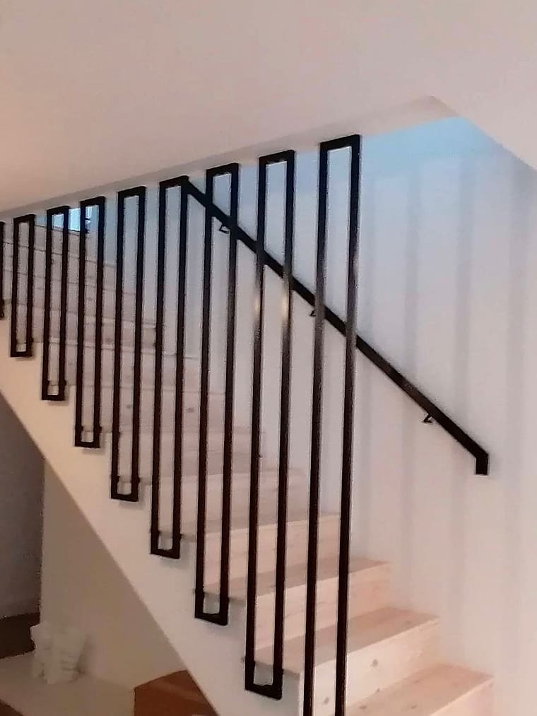 Klatka schodowa po montażu schodów i stalowej balustrady.